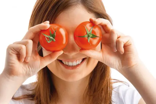 Лицо девушки и 2 помидора в руках