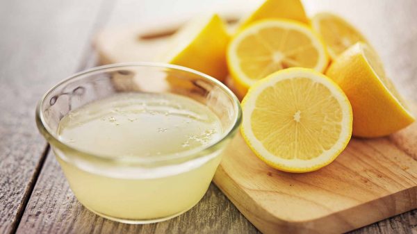 Сок лимона в прозрачной пиале и плоды